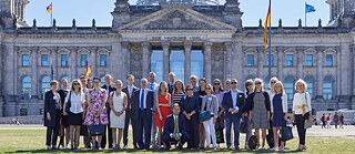 Teilnehmer*innen des Netzwerktreffens 2018 stehen in einer Gruppe vor dem Bundestag in Berlin