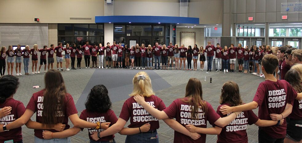 Students standing arm in arm in a circle