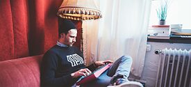 Fynn sitzt mit Synthesizer auf der Couch