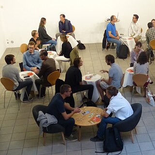 Des gens assis autour de tables qui discutent