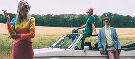 Die Band Blond steht mit einem Auto im Feld