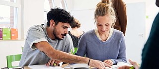 Zwei Lernende arbeiten konzentriert gemeinsam im Sprachkurs.