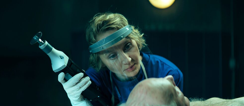 Serienfieber Totenfrau Banner Blum (Anna Maria Mühe) bereitet die Leiche von Eberhard Pichler (Robert Sadil) für die Bestattung vor. In der Hand hält sie eine Knochensäge.