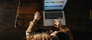 Ein Mädchen lernt vor einem Laptop
