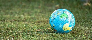 Ein Ball in Form der Erde auf einem Stück Rasen