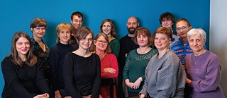 Team Goethe-Institut Lyon 2024 Eine Gruppe lächelnder Frauen und Männer vor blauem Hintergrund
