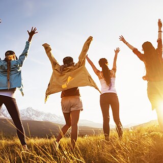 Gruppe von jungen Leuten mit erhobenen Armen