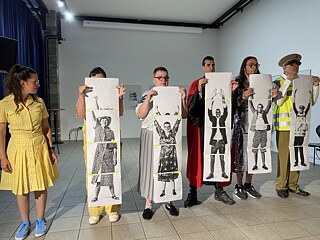 mehrere Menschen stehen in einer Reihe nebeneinander und halten Fotos ihrer Körper vor sich