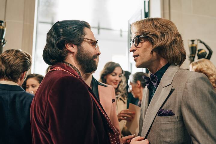In a scene from the series "Becoming Karl Lagerfeld", Yves Saint-Laurent and Karl Lagerfeld look at each other, both seen from the side.