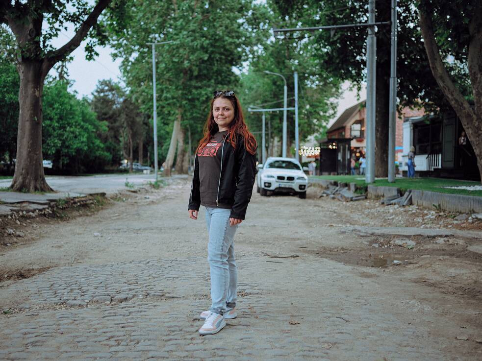 37-ročná zakladateľka start-upu Mihaela Cebotari stojí na dlážobných kockách z 19. storočia, na mieste kde sa náhle končí nový cyklochodník v centre Kišiňova.