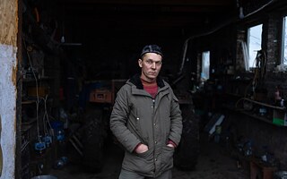 Ihor Kňazev pri dome, ktorý postavil z toho, čo ostalo po vojne. Obec Dovheňke, Charkivská oblasť, 25. januára 2025