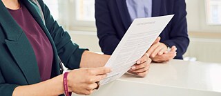 Two people in a close-up. One person receives a certificate.