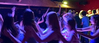 Jugendliche tanzen im Neonlicht.