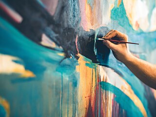 An artist paints a picture. Close-up of the hand and brush.