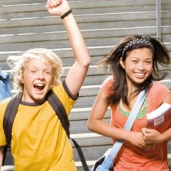 A boy and a girl happily running down a flight of stairs. 