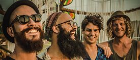 Die vier Bandmitglieder lachend in der Sonne
