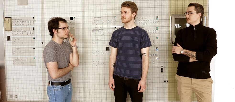 Nuage & Das Bassorchester 3 junge Männer vor Schaltwand