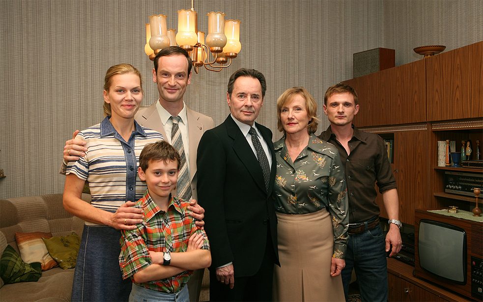 <b>Weissensee</b><br><i>Weissensee</i> ist eine Serie über den Niedergang der DDR und über zwei Familien in Ost-Berlin, die gegensätzlicher nicht sein könnten: Während eine Familie stramm regimetreu für die Stasi arbeitet, zählt sich die andere zum kritischen Milieu. Es geht um Liebesbeziehungen zwischen den zwei Angehörigen zweier grundverschiedener Familien, Verrat, Gier, Kampf und Macht. Doch <i>Weissensee</i> ist auch Politthriller, bei dem die deutsche Geschichte vor, während und nach der Wiedervereinigung eine wichtige Rolle spielt.
