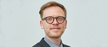 Porträt von Markus Gabriel, stehend mit Brille