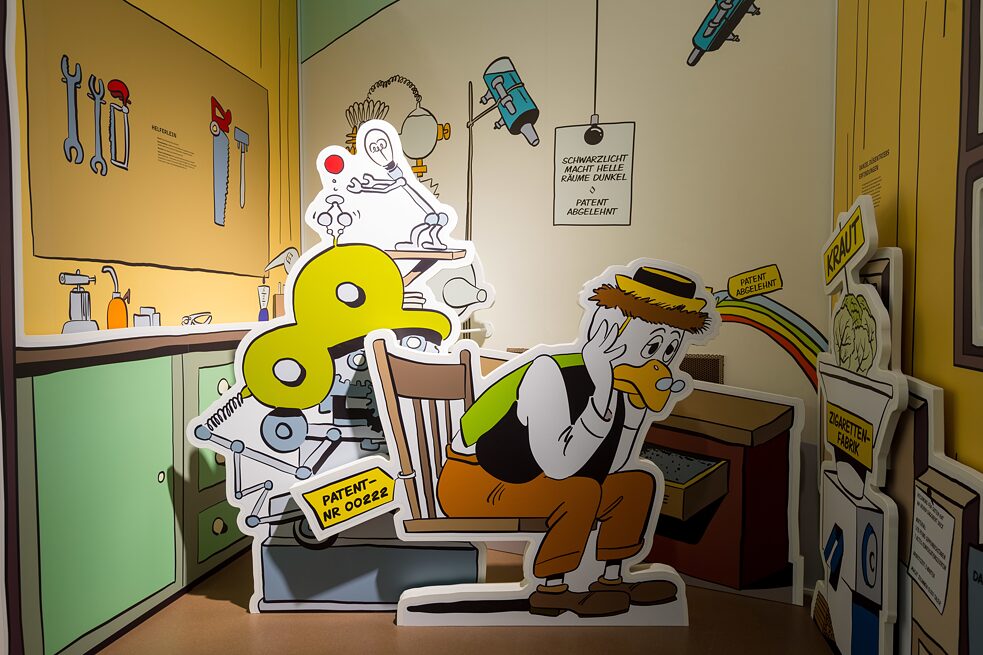 In einem begehbaren Entenhausen können Kinder nicht nur Daniel Düsentrieb in seiner Werkstatt über die Schulter schauen, sondern auch Dagobert Ducks Talerbad oder den Klettertunnel hinter Oma Ducks Scheune ausprobieren. 