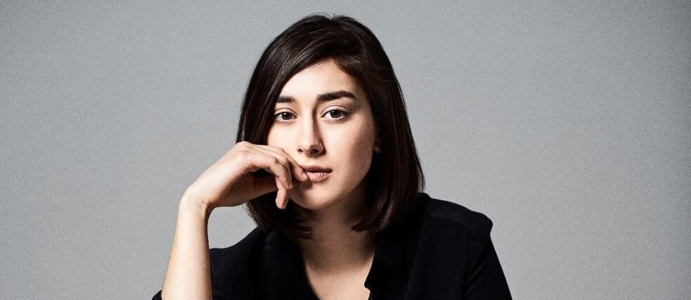 ELIF Junge Frau mit schwarzem Haar und schwarzem Anzug