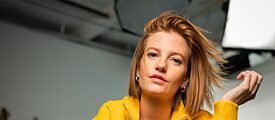 Frau mit gelbem Pulli sitzend