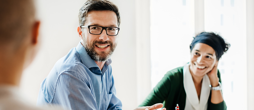 Mann und Frau tauschen sich im Arbeitskontext aus