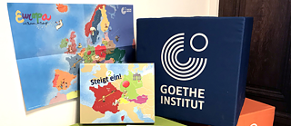 Sitzwürfel in grün, orange und blau mit Goethe Logo und Spiel Steigt ein