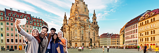 İnsanlar Dresden'deki Frauenkirche kilisesi önünde selfie çekiyor.