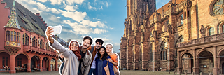 Le persone scattano una foto davanti alla cattedrale di Friburgo.