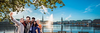 İnsanlar Hamburg'daki Binnenalster'ın önünde selfie çekiyor.