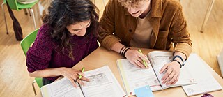 Junge Frau beim Lernen und Deutschlehrer